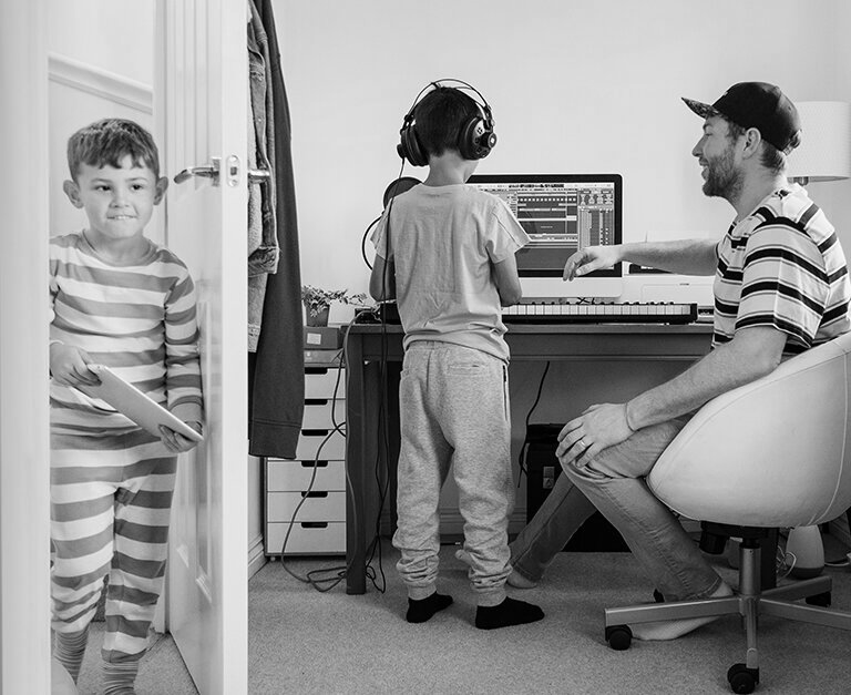 Dad with kids in front of a computer and a keyboard